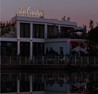 Facade of La Cantine restaurant in the evening with reflections in the water