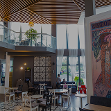 Interior of La Cantine restaurant with a two-level hall and stained-glass windows