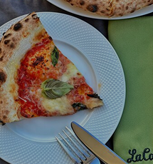 Pizza with tomatoes and basil on a plate at La Cantine restaurant